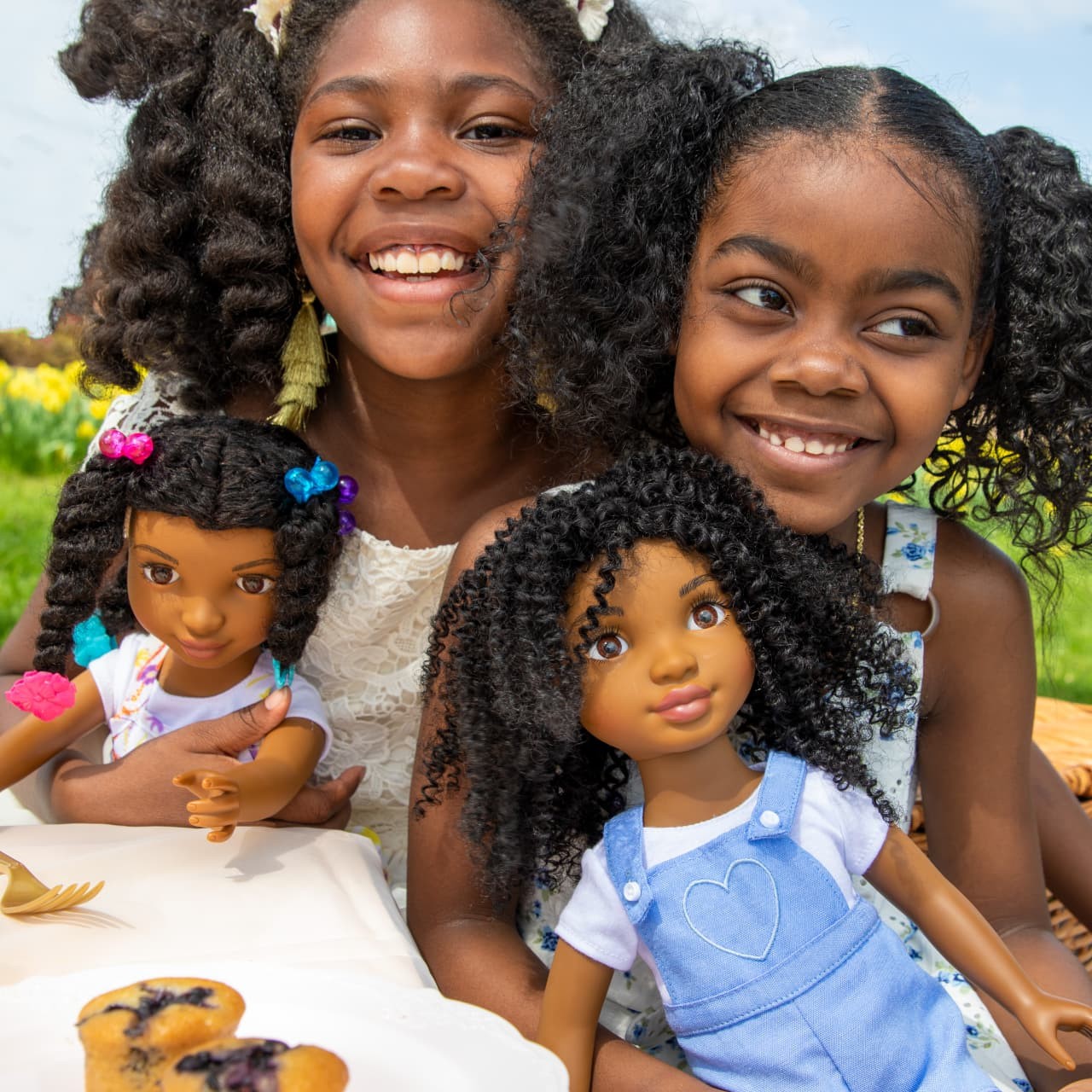 Girls loving their Healthy Roots Dolls at a sunny picnic